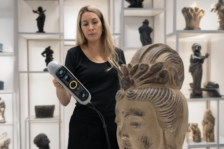 Woman dressed in black using the HP DesignScan to scan a statue in a museum